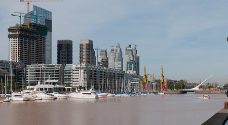 Yachts and harbor cranes on the background of skyscrapersの写真素材