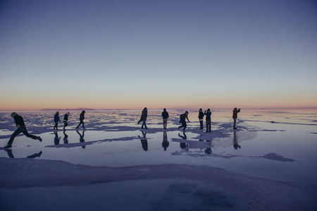 BOLIVIA, UYUNI-APRIL, 2011:Tourists walking along the expanse of Salar de Uyuniのeditorial素材