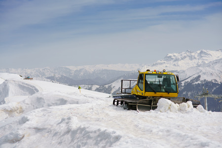 snowcat on ski slope on a background of mountain peaksの写真素材