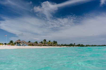 The boat in the waters of the Caribbean Sea and the view of the beach of Cayo Largo, Cuba out of the waterの写真素材