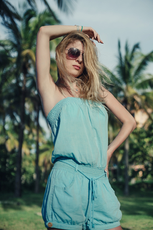 blonde in blue suit next to Palm treesの写真素材