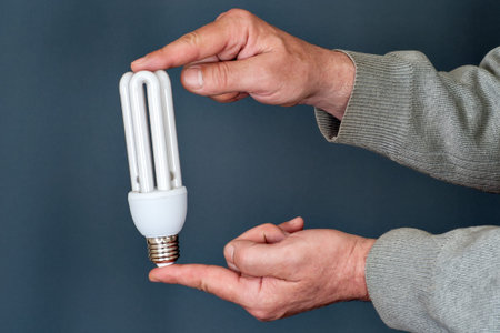 man s hands holding an energy saving bulbの写真素材