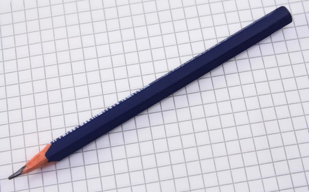 dark blue pencil on the squared paper backgroundの写真素材