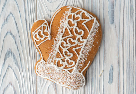 Gingerbread spice cookie in form of winter mitten with hearts.の写真素材