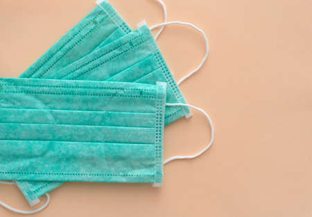 Medical green facial masks on pink background, anti-infective hygienic and health protection concept, Coronavirus Covid-19 preventionの写真素材