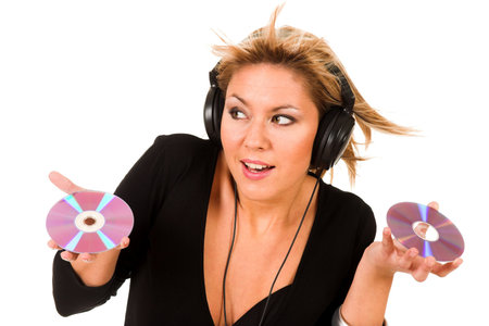 beautiful young woman listening music in headphones and holding two CD