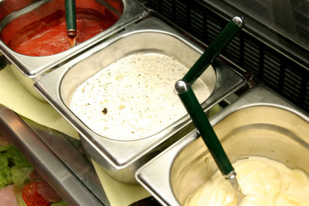 Rows of food ingredients for hot dog, sandwich and hamburger in restaurantの写真素材