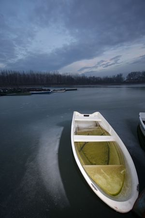 old boat on frozen river Danube in januaryの写真素材