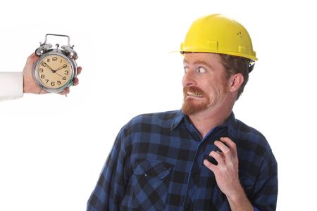 confused construction worker looking at his watchの写真素材