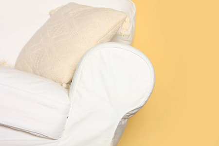 Details shot of a white couch near yellow wallの写真素材