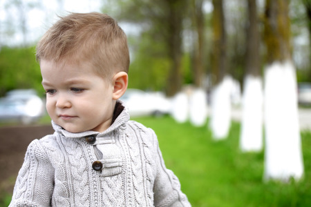 Trendy 2 years old baby boy posing in spring/autumn parkの写真素材