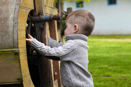 2 years old curious Baby boy managing with old agricultural Machineryの写真素材