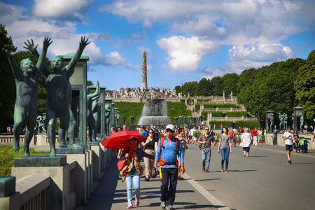EDITORIAL OSLO, NORWAY - AUGUST 18, 2016: Many tourist walk Vigeland Sculptures Park in the popular Vigeland park ( Frogner Park ), designed by Gustav Vigeland in Oslo, Norway on August 18, 2016.のeditorial素材