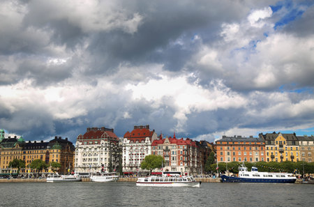 STOCKHOLM, SWEDEN - AUGUST 20, 2016: Many people walk and visit on Strandvagen street on Ostermalm distric with touristic sightseeing boats in Stockholm, Sweden on August 20, 2016.のeditorial素材