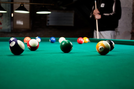 Billiard balls / A Vintage style photo from a billiard balls in a pool table. Noise added for a film effectの写真素材