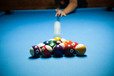 Blue billiard table with colorful balls, beginning of game, slow motion, soft focus, snooker bar,...