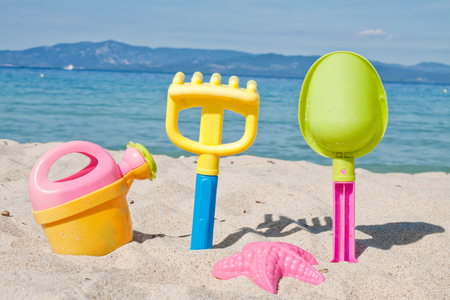 Children's beach toys - buckets, spade and shovel on sand on a の写真素材