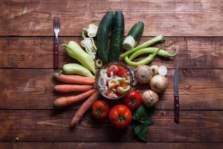 healthy fresh vegetarian salad in a bowl, fresh raw vegetables on background, top view.の写真素材