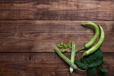 Fresh green chillies on wooden chopping board..の写真素材