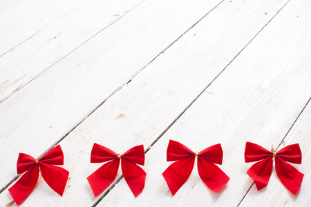Decorative red ribbon and bow on a background of white painted rustic boardsの写真素材