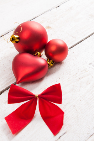 Red Christmas decorations and bow on a wooden background.の写真素材