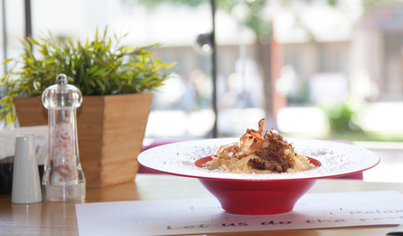 Pasta Carbonara with ham and cheese served in restourant on a red plate.の写真素材