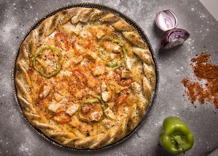 Food ingredients and spices for cooking mushrooms, tomatoes, cheese, onion, pepper, salt, and delicious italian pizza on black concrete background. Copyspace. Top view. Banner.の写真素材