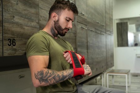 Handsome male with tattoos in his 20s getting ready for training