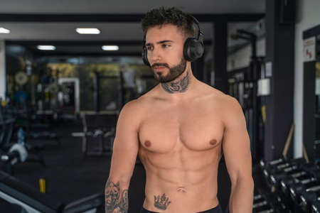 Handsome male with tattoos in his 20s in the gymの写真素材