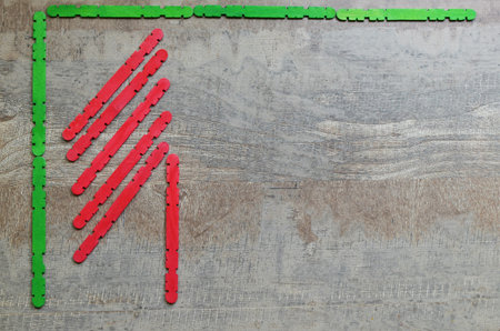 Christmas composition: a frame made of green wooden sticks, and half of a Christmas tree made of red...