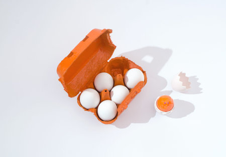 2021 Easter minimal creative concept. Five white eggs in a bright orange box on a white background....