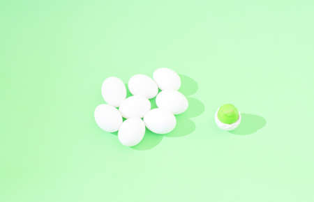 2021 Easter, minimal creative concept. White whole eggs and a broken one with green yolk, on pastel green background. Creative flat lay. Still life composition.の写真素材