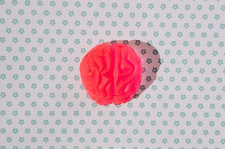 A luminous pink human brain on a dotted blue and white background. Smart attitude creative concept. Halloween 2021 artistic conceptの写真素材