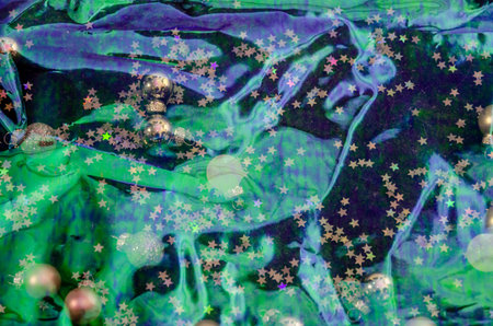 Holographic background or backdrop in lilac, purple and green tones with Christmas decoration below...
