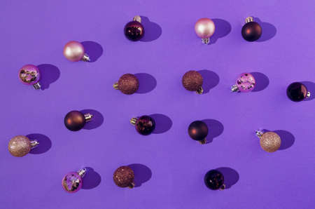 A pattern or wallpaper made of Christmas baubles in brown and golden on saturated violet background. Trending color background. Design for banner or card or web banner.の写真素材