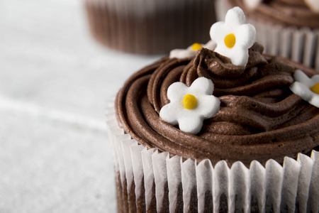 Close up of a nicely decorated chocolate cupcake on a wooden backgroundの写真素材