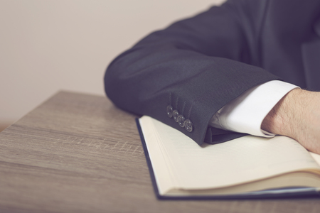 Detail of a judge sitting at his desk, studying new laws and legislation. Selective focusの写真素材