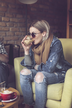 Beautiful young woman sitting in a cafe, having her morning cup of coffeeの写真素材