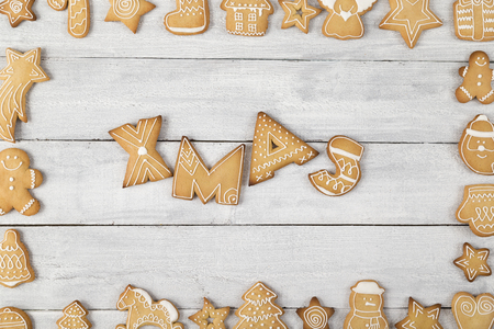 Table top shot of a frame made of nicely decorated gingerbread cookies with Xmas written within the frameの写真素材