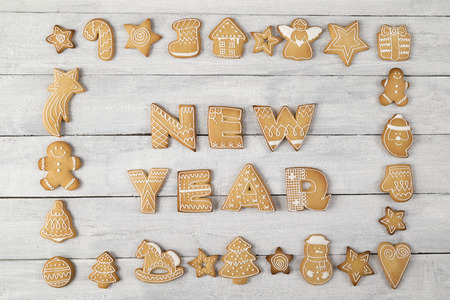 Table top shot of a frame made of nicely decorated gingerbread cookies with New Year written within the frameの写真素材