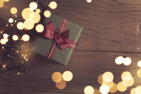 Table top shot of a nicely deocrated gift box and Christmas lightsの写真素材