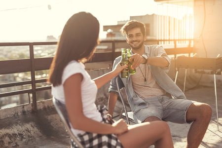 Cheerful young couple having fun at a rooftop barbecue partyの写真素材