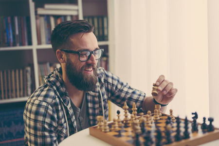 Man playing chess at home, enjoying his leisure timeの写真素材