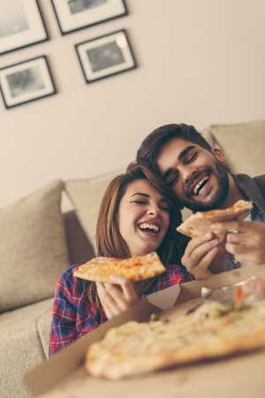 Couple in love eating pizza and having funの写真素材
