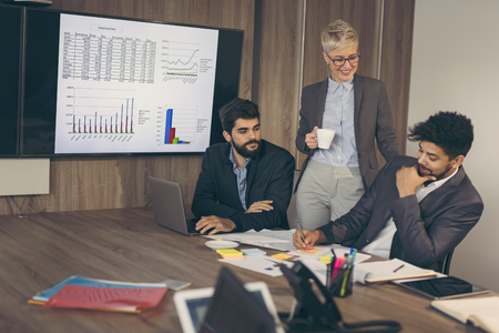 Group of business people on a meeting in a conference room, brainstorming. Focus on the woman and the man on the leftの写真素材
