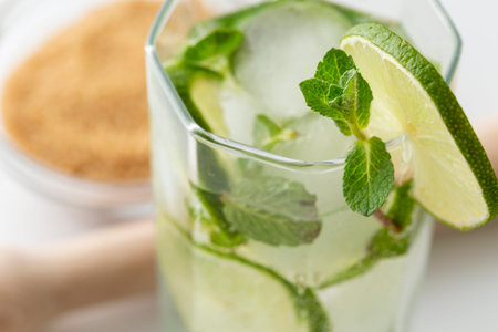 Mojito cocktail with lots of ice, white rum, lemon juice and tonic, decorated with lime slices and...