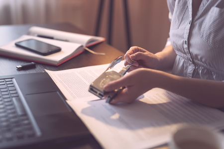 Detail of female hands holding a stapler and filling it with the staples. Selective focus on the thumb and the staplerの写真素材