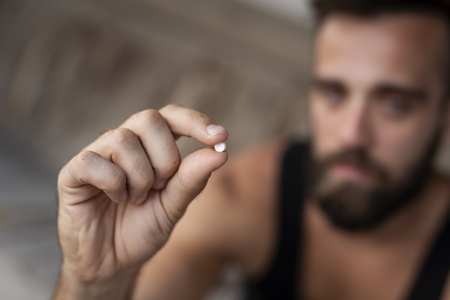 Man holding an ecstasy pill. Focus on the pillの写真素材