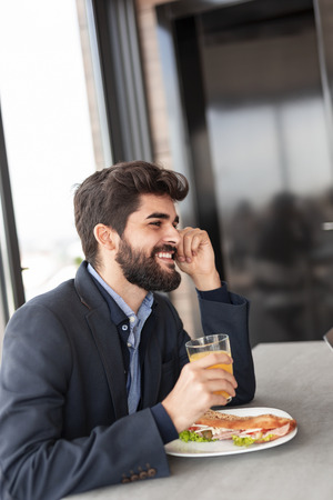 Businessman taking a lunch break and having a meal in company's restaurantの写真素材