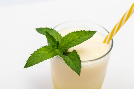 Glass of cold melon juice, decorated with mint leaves, isolated on white background